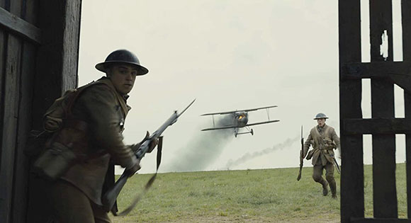 A German plane lands near two British soldiers in 1917.