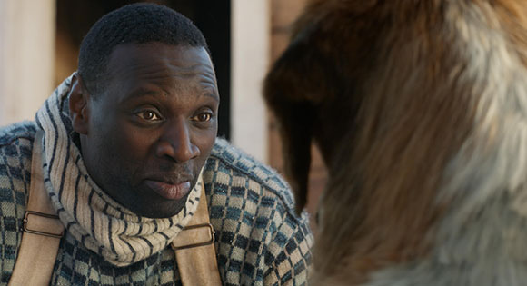 Omar Sy as a sled driver with Buck in The Call of the Wild