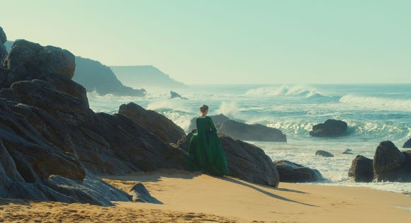 Adèle Haenel as Héloïse by the rocky shore of the beach in Portrait of a Woman on Fire