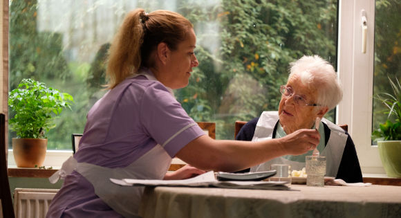 Debbie Honeywood as Abbie with a nursing home resident in Sorry We MIssed You