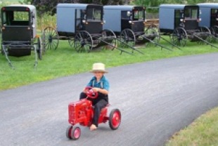Amish boy on toy tractor