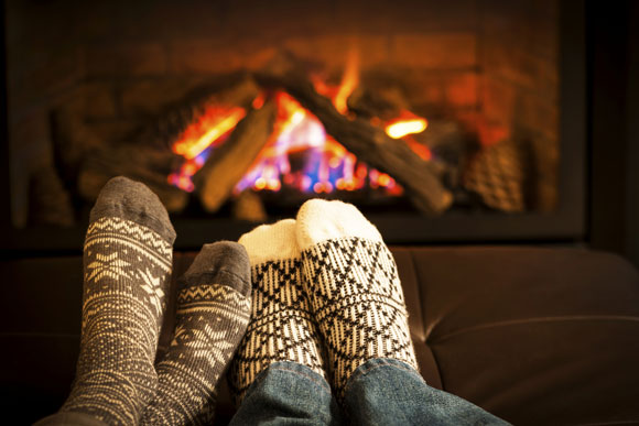 socking covered feet in front of a fireplace