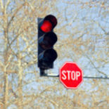 A stop light overhead with a stop sign under it.