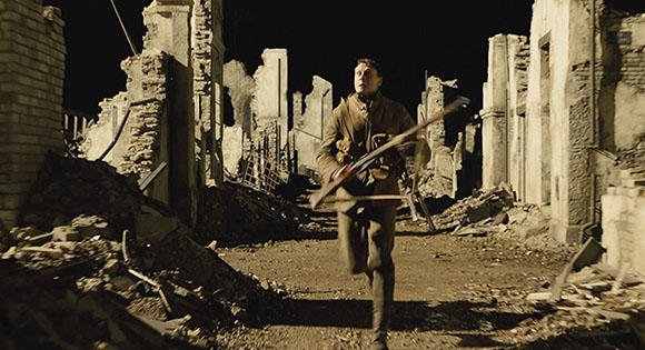 George MacKay as Schofield running to deliver a life-saving message in 1917.