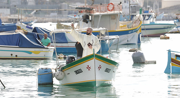 Reeee Vella as the priest blessing the fishing boats