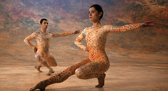 female and male dancer in spotted leotards against a spotted stage in Cunningham