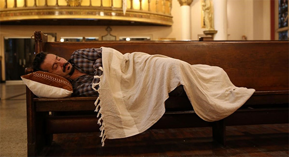 Paul) Max Casella) sleeps in the church.