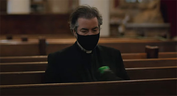 Father Andrew (Kevin Corrigan) sanitizing the pew.