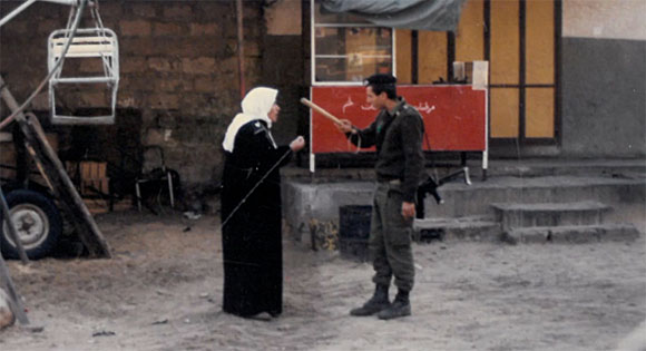 Soldier with club confronting Palestinian woman